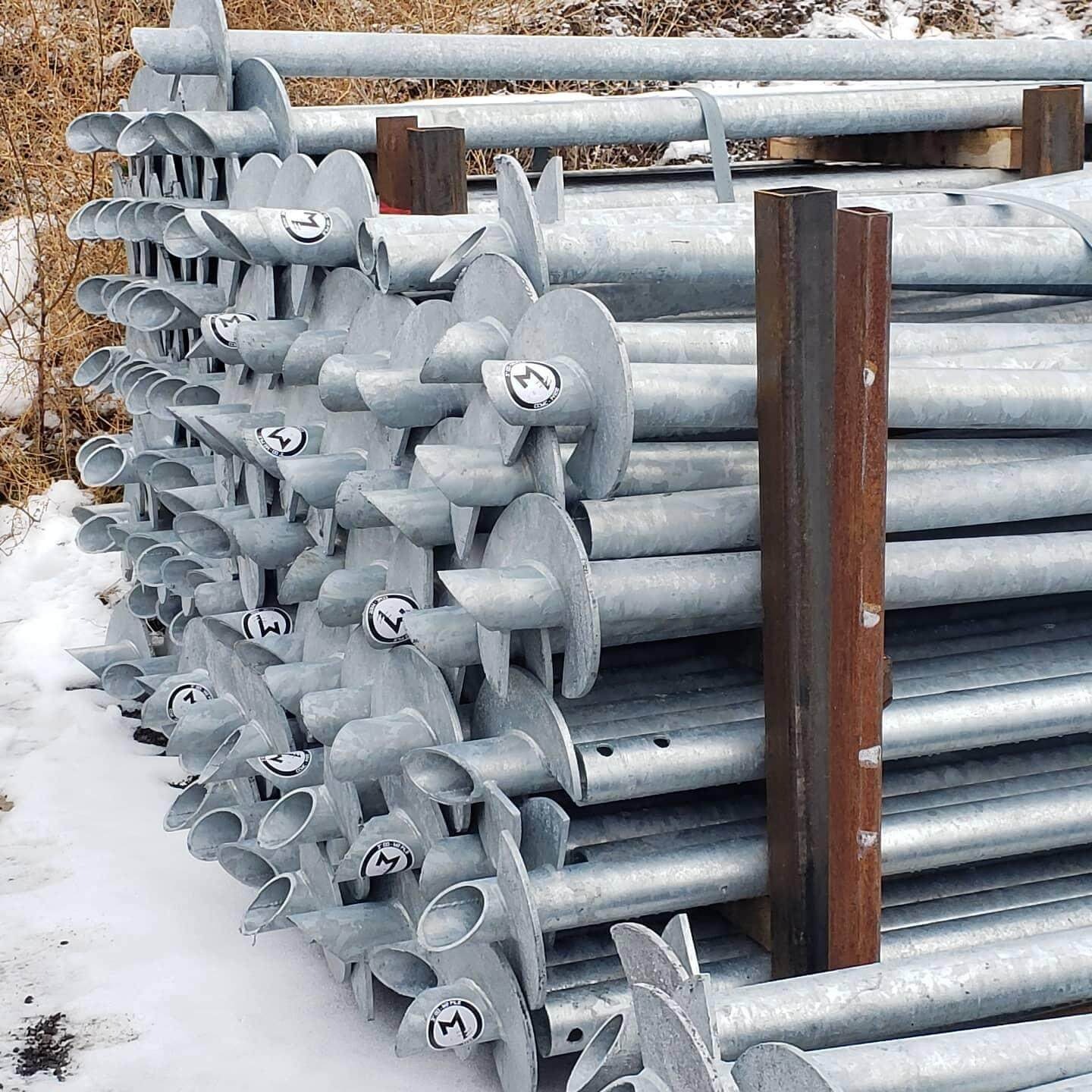 Helical piles stacked on snowy ground