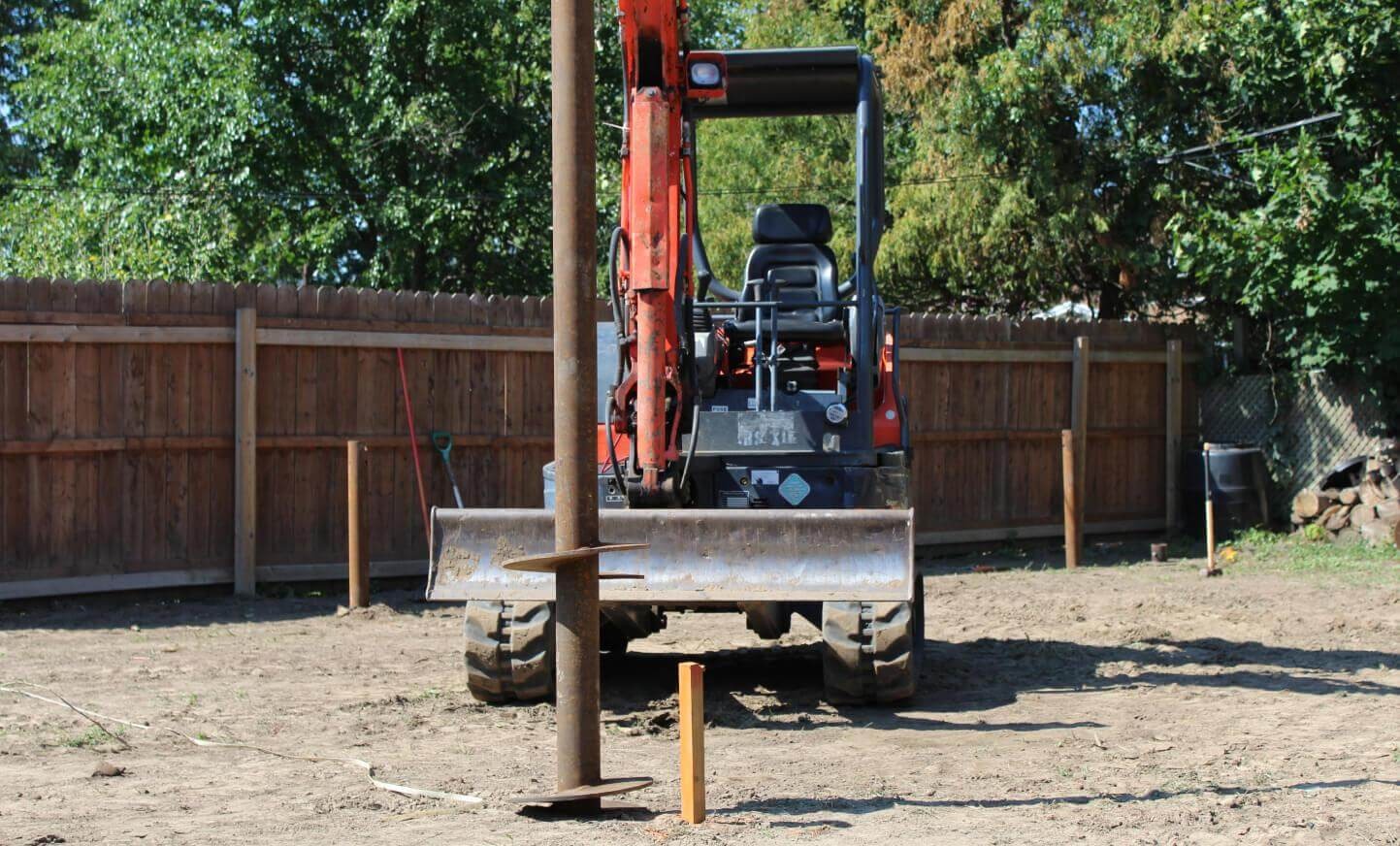 Tractor parked by wooden fence in rural setting