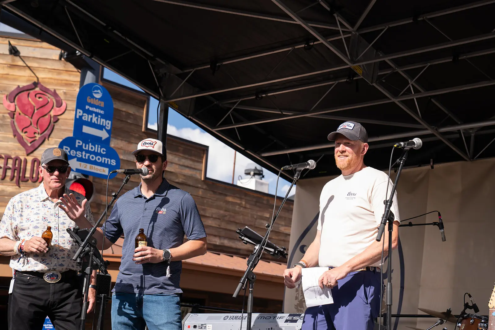 Speakers address the crowd on an outdoor stage for Lisa Zimmer's Coors testimonial video