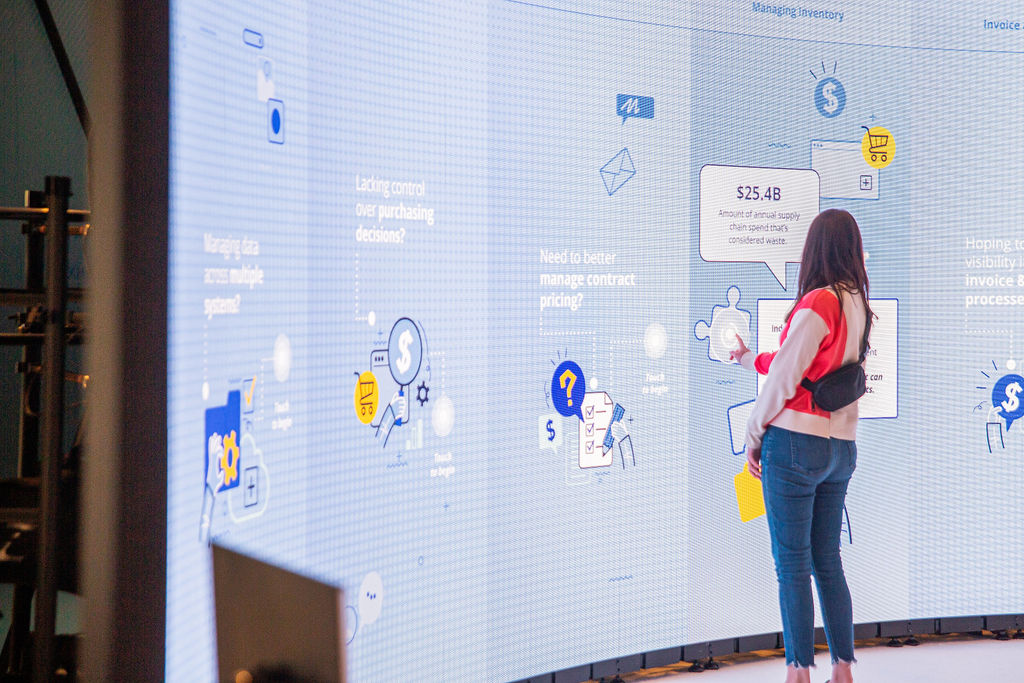 An Imprint-designed interactive data wall lets an attendee engage with GHX product demos