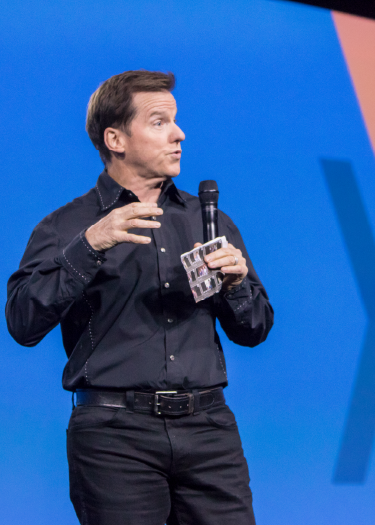 A speaker addresses attendees on Imprint's diamond-shaped stage design at the Mellanox Conference