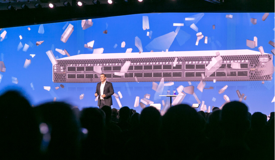 A presenter unveils networking hardware on Imprint's custom-built screen at the Mellanox Conference