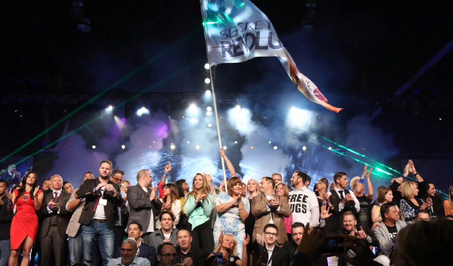 An attendee waves a flag during Imprint's tailor-made entertainment at the Seacret Conference