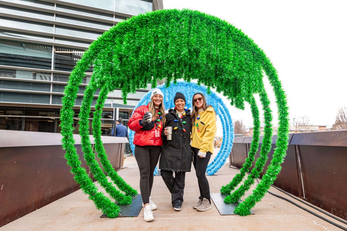 Guests pose at Imprint's tinsel arch photo op, part of the Corporate Holiday Market village