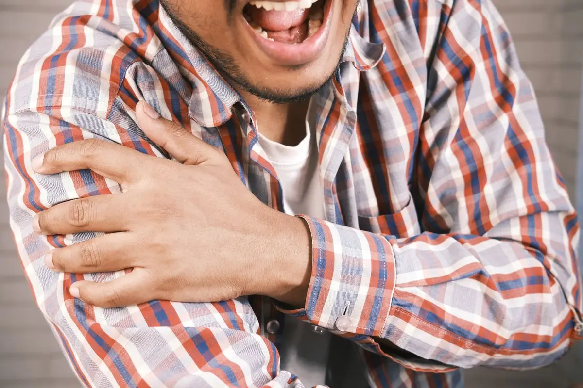 A man grasping his shoulder in pain