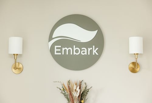 Physiotherapist from Embark Physical Therapy & Wellness Team providing hands-on manual therapy to a patient while smiling during treatment