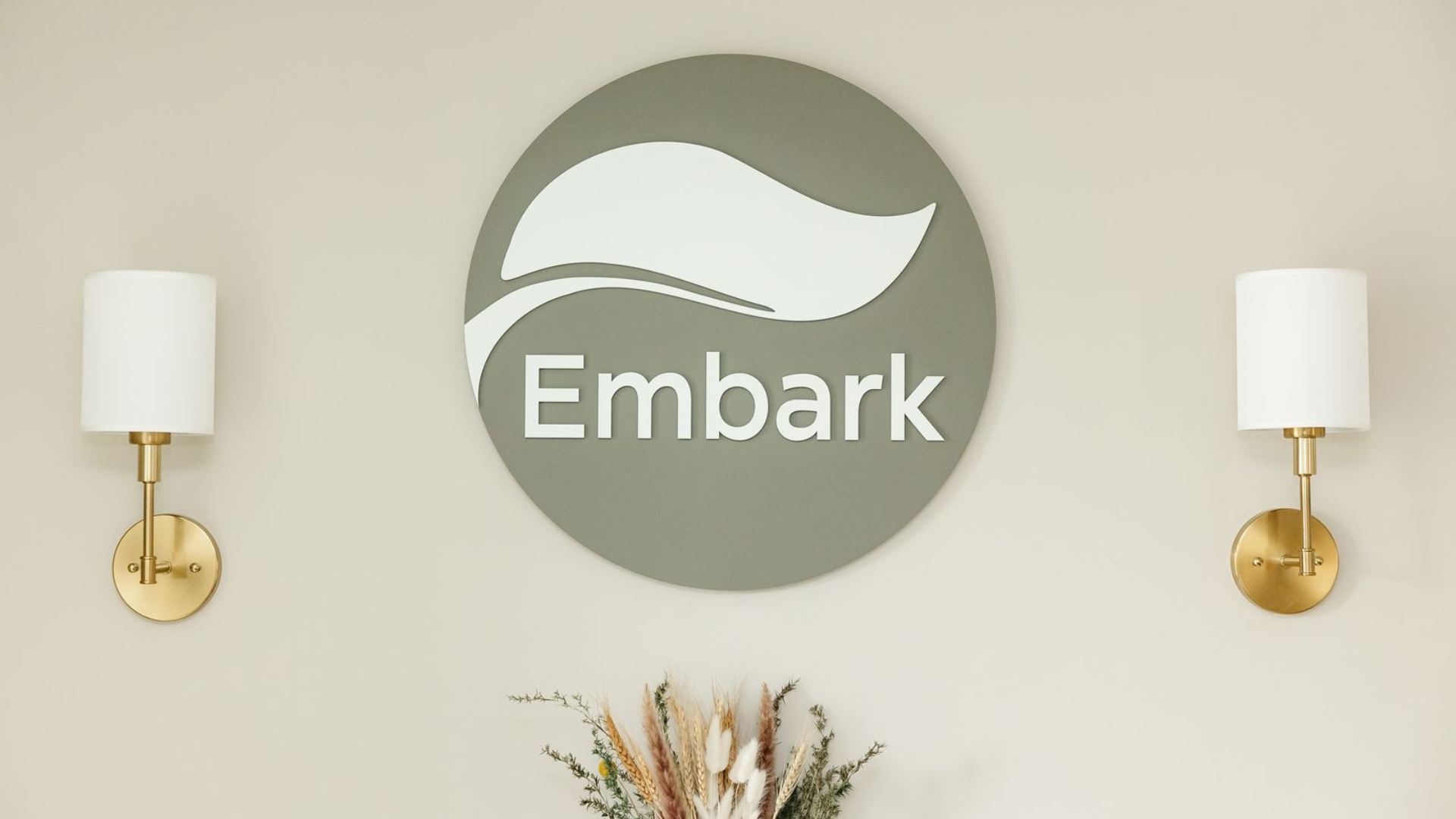 Physiotherapist from Embark Physical Therapy & Wellness Team providing hands-on manual therapy to a patient while smiling during treatment