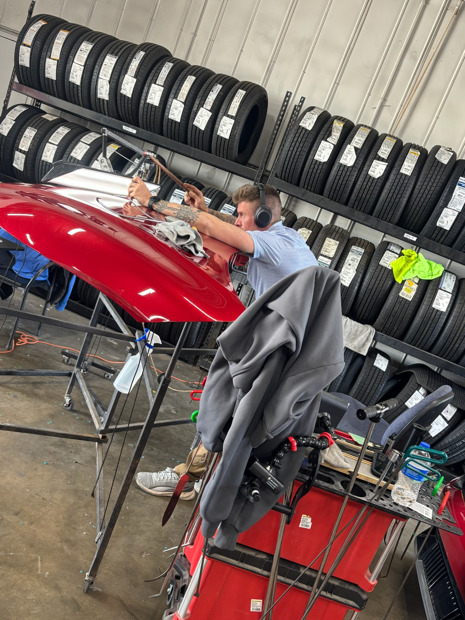 Technician wiping a vehicle panel with a microfiber cloth after PDR