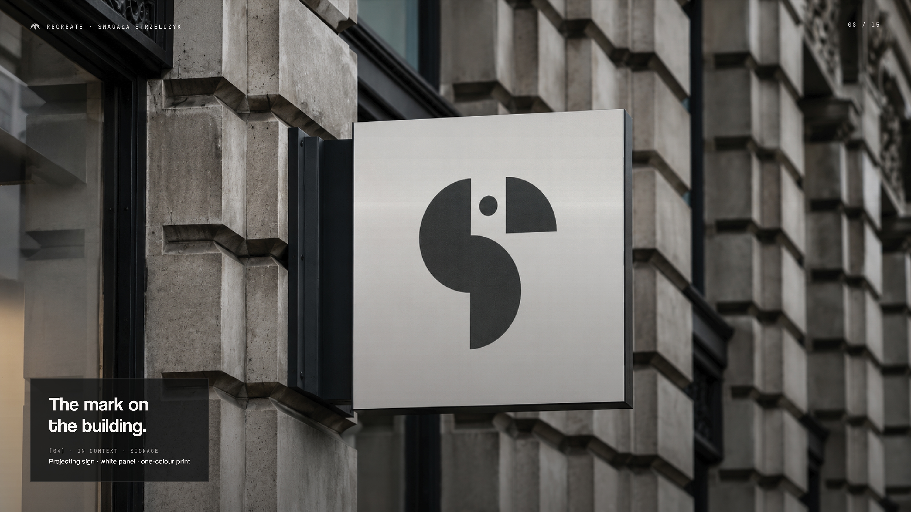 Szyld zewnętrzny kancelarii Smagała Strzelczyk — biały panel z grafitowym logiem papugi zamontowany prostopadle na fasadzie kamienicy; ciepłe boczne światło na szarej elewacji; opis: The mark on the building