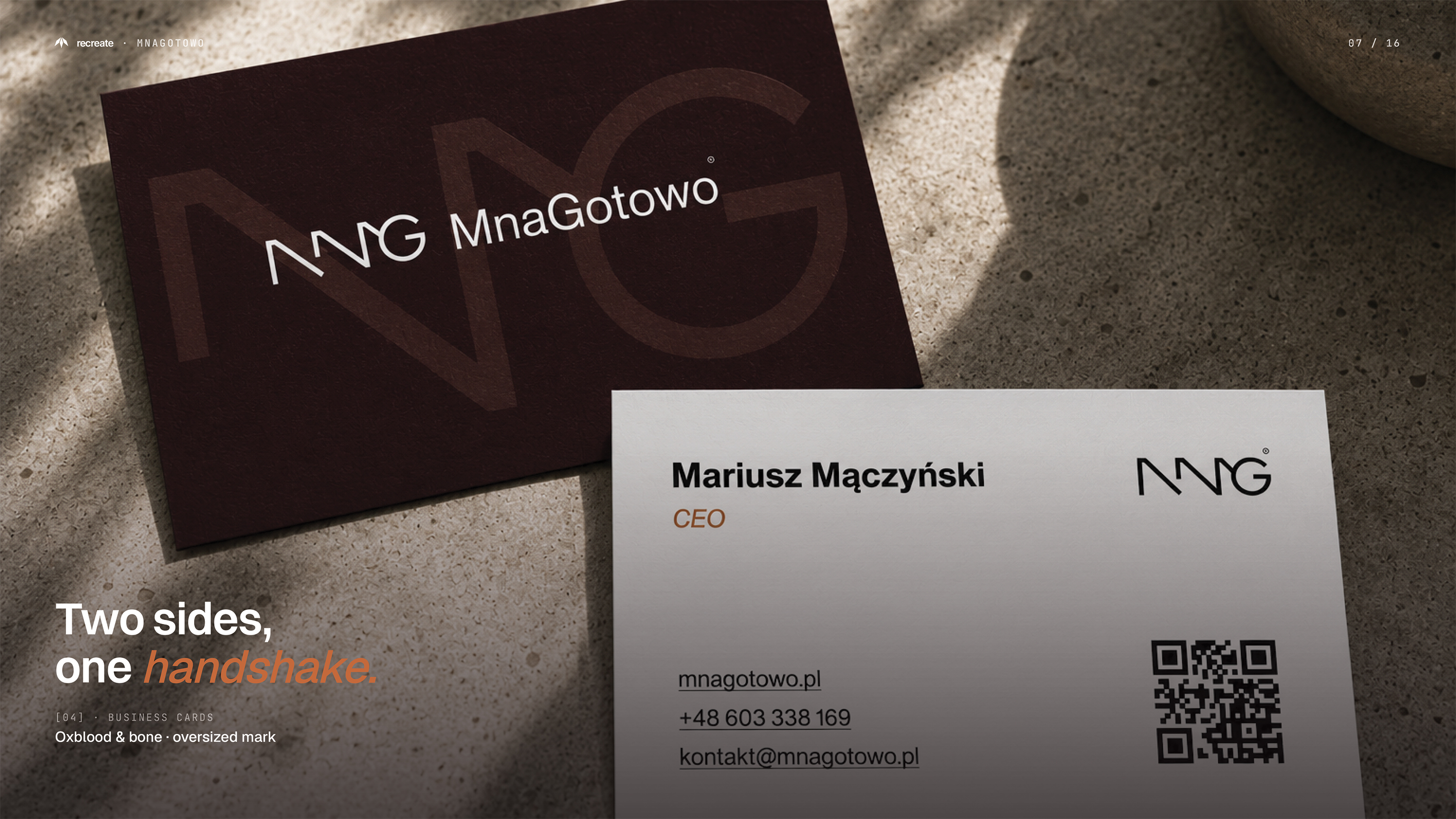 MnaGotowo business cards — oxblood and bone double-sided cards with oversized MnG mark on stone surface