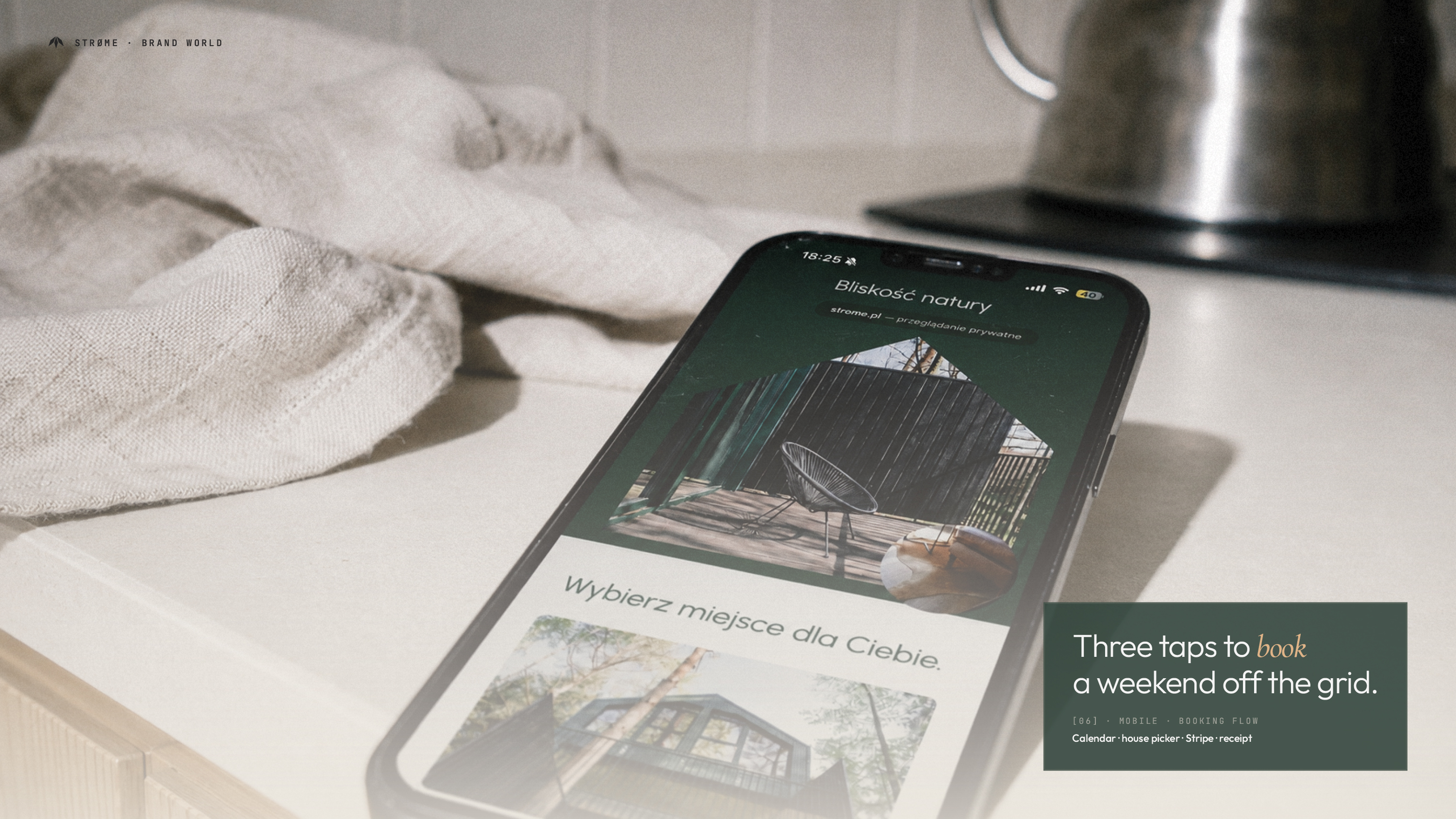 Mockup mobilny strony Strøme na ekranie iPhone'a — widok kalendarza rezerwacji z trzema domkami i przyciskami dostępności; telefon leży na beżowej tkaninie obok gałązek jodły