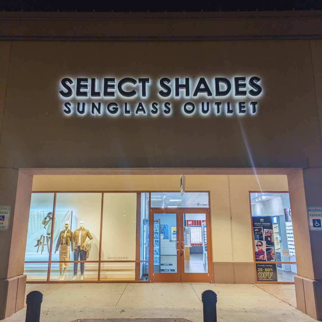 Select Shades Sunglass Outlet storefront at Allen Premium Outlets in Allen, TX, featuring illuminated signage and premium eyewear displays near Banana Republic.