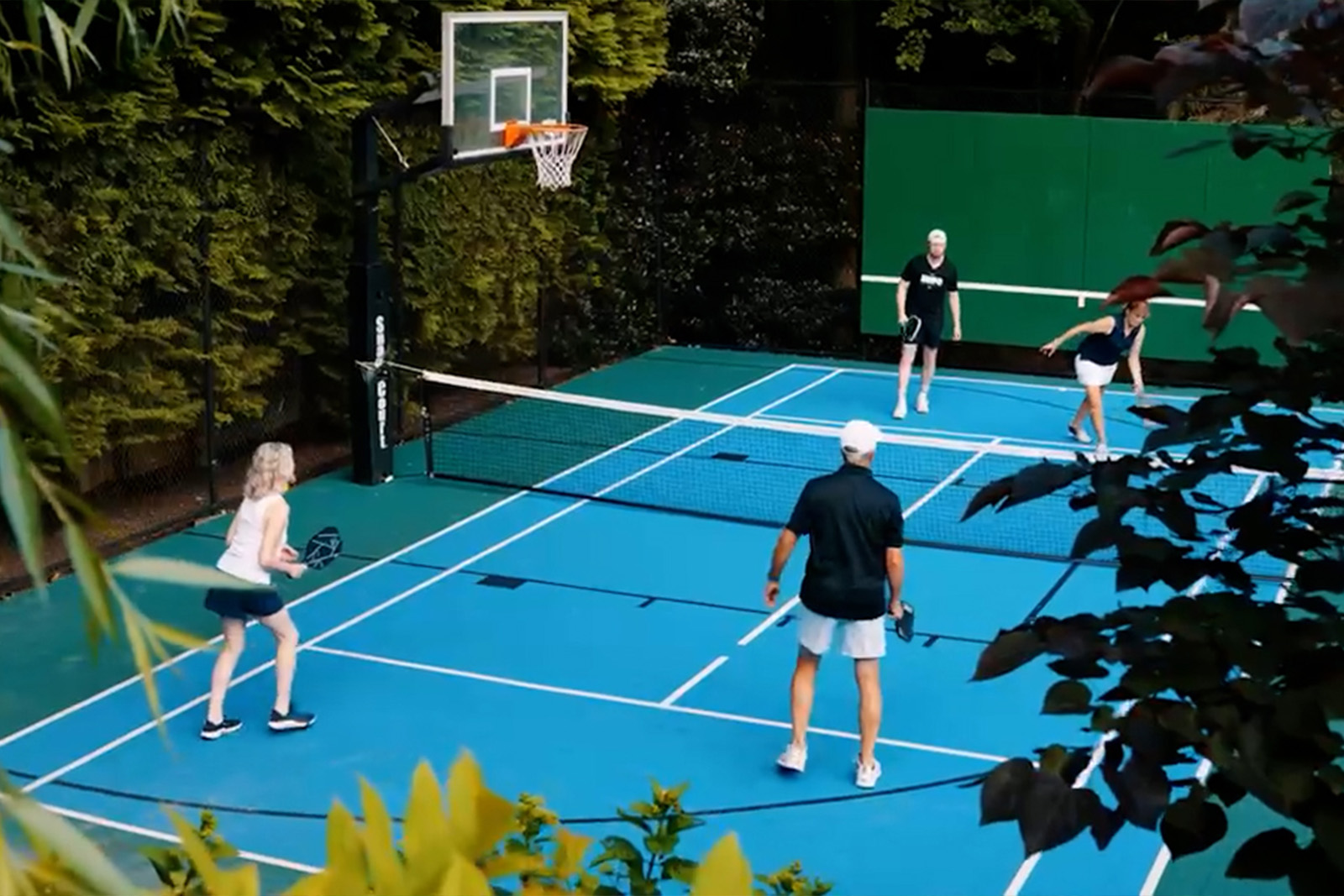 Doubles pickleball game played on a multi-purpose sport court.