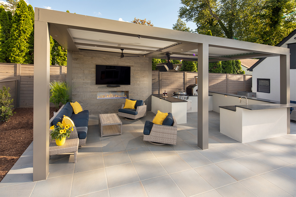 A custom pergola sits next to the swimming pool, complete with an outdoor kitchen, bar, TV, and fire features.