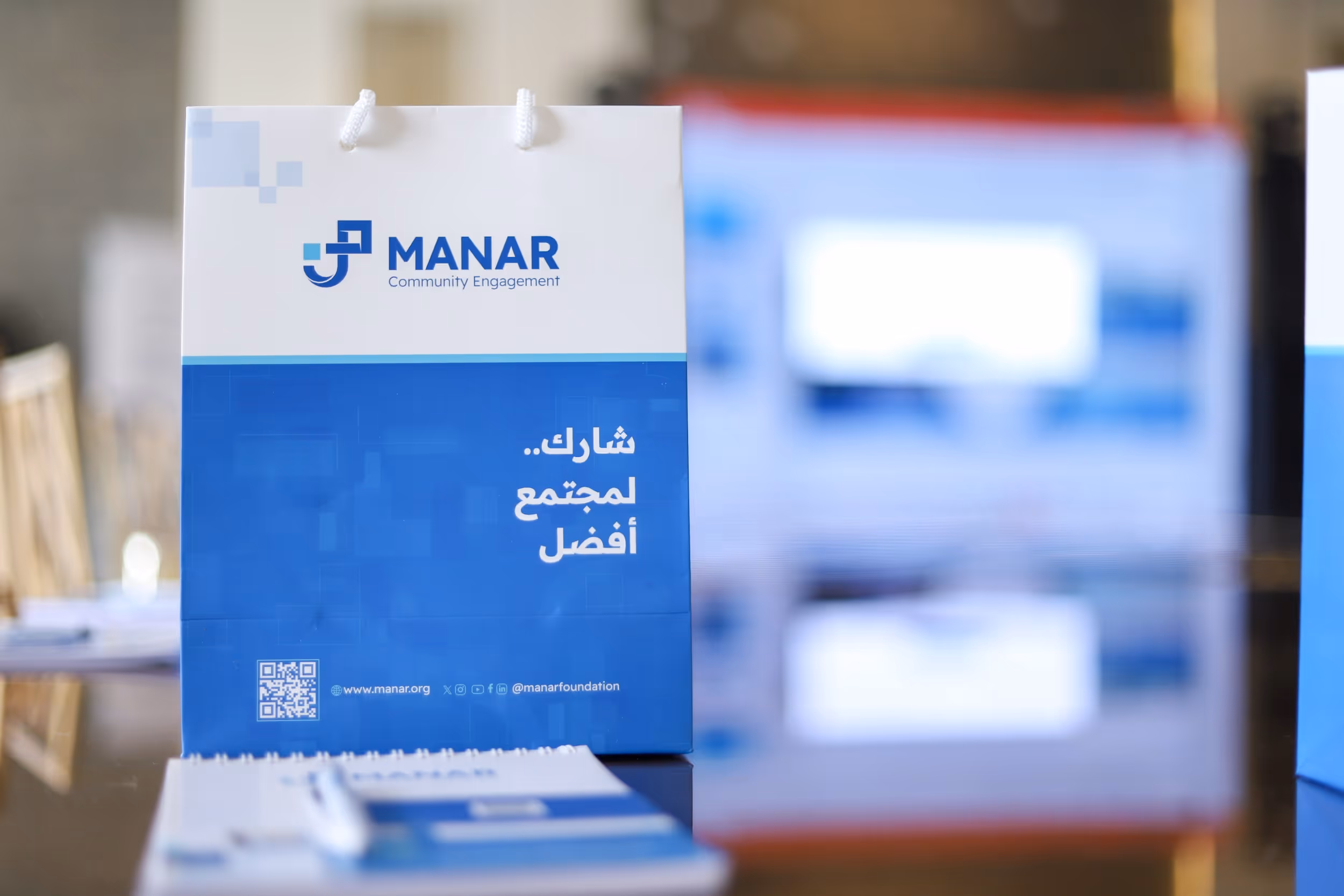 محاضر يقدم عرضًا أمام جمهور في فعالية لمنار يعبر عن المشاركة المجتمعية وأهمية التنمية المستدامة وتمكين المجتمعات والشراكات المجتمعية