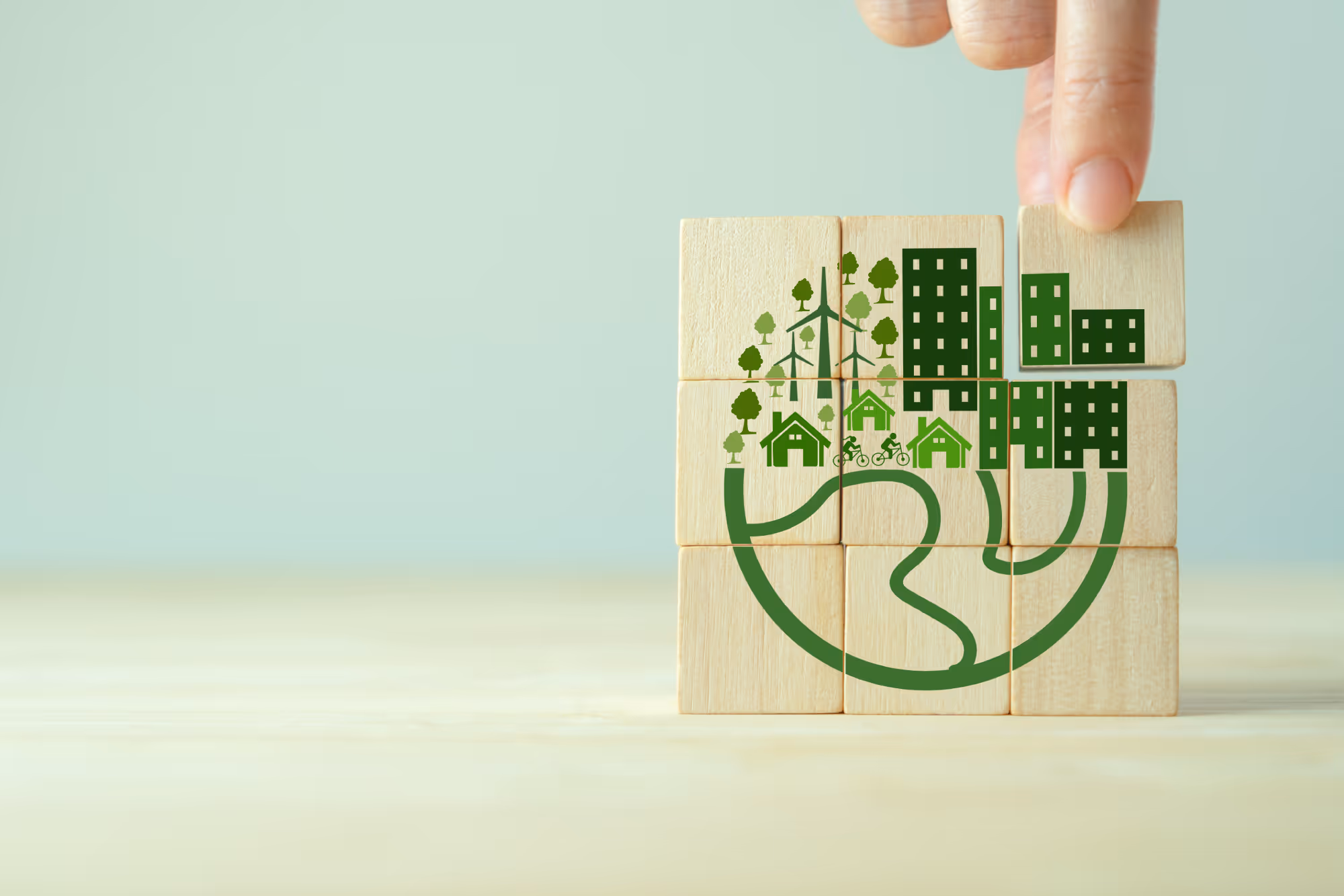 كتلة خشبية مطبوعة عليها رمز مدينة خضراء يعبر عن التنمية المستدامة والاستثمار الاجتماعي وحماية البيئة وتمكين المجتمع