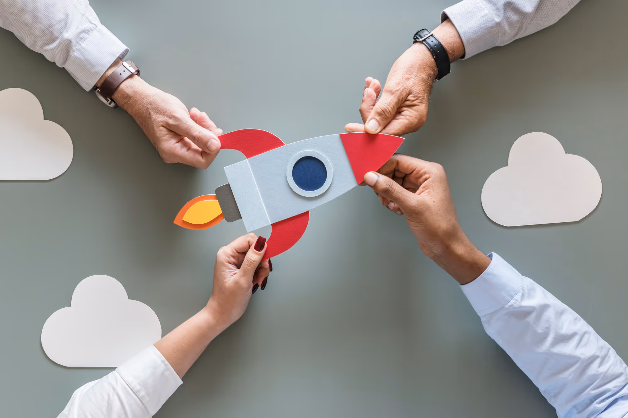 أربعة أيدي تمسك قطع أحجية متصلة ترمز إلى المشاركة المجتمعية والشراكات المجتمعية والتنمية المستدامة وتمكين المجتمع