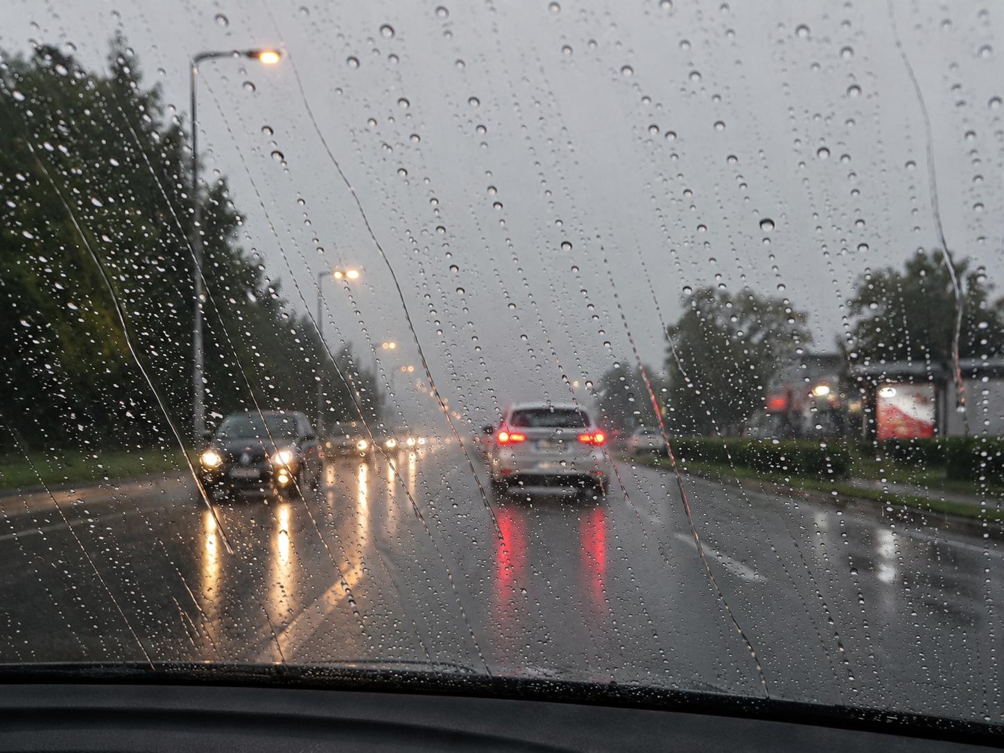 View through windscreen with Si-Plus — water beading and rolling off, clear visibility in Singapore rain