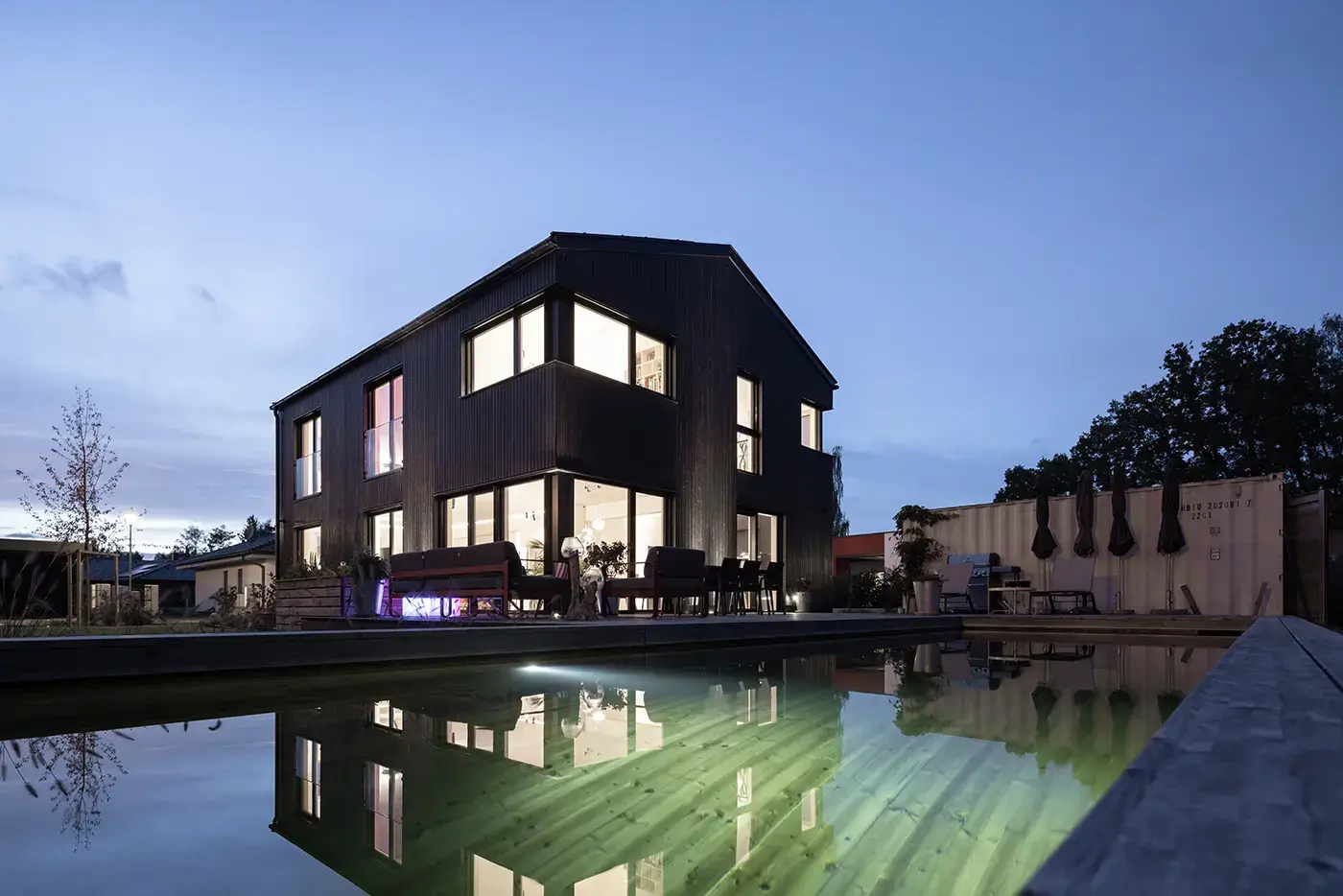 GRIFFNER Haus Kundenhaus Außenansicht mit Holzpool bei Nacht
