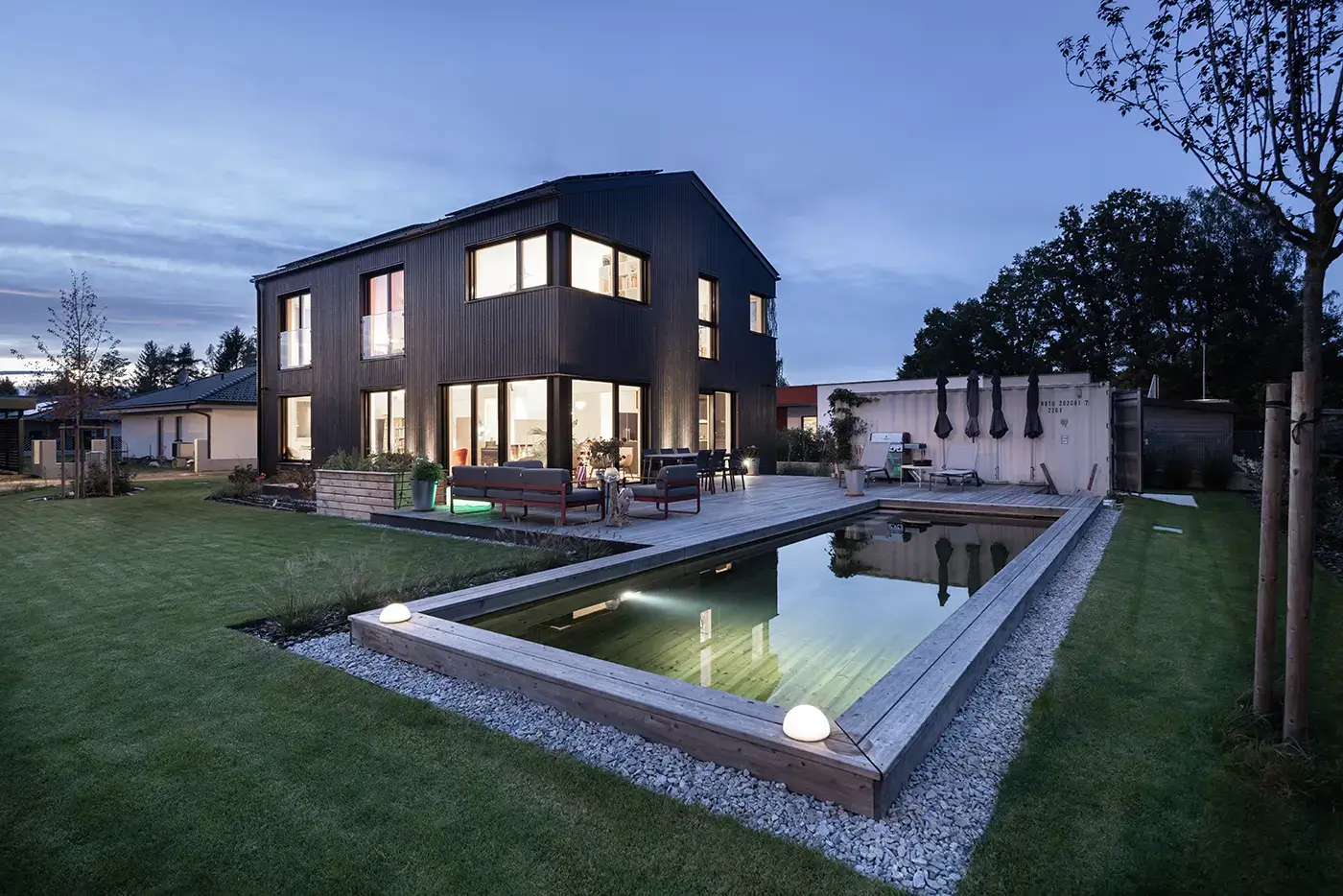 GRIFFNER Haus Kundenhaus Außenansicht mit Holzpool bei Nacht