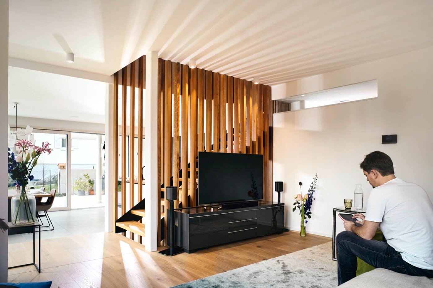 Wohnbereich eines Fertigteilhauses mit Holzlammellen als natürliches Gestaltungselement.