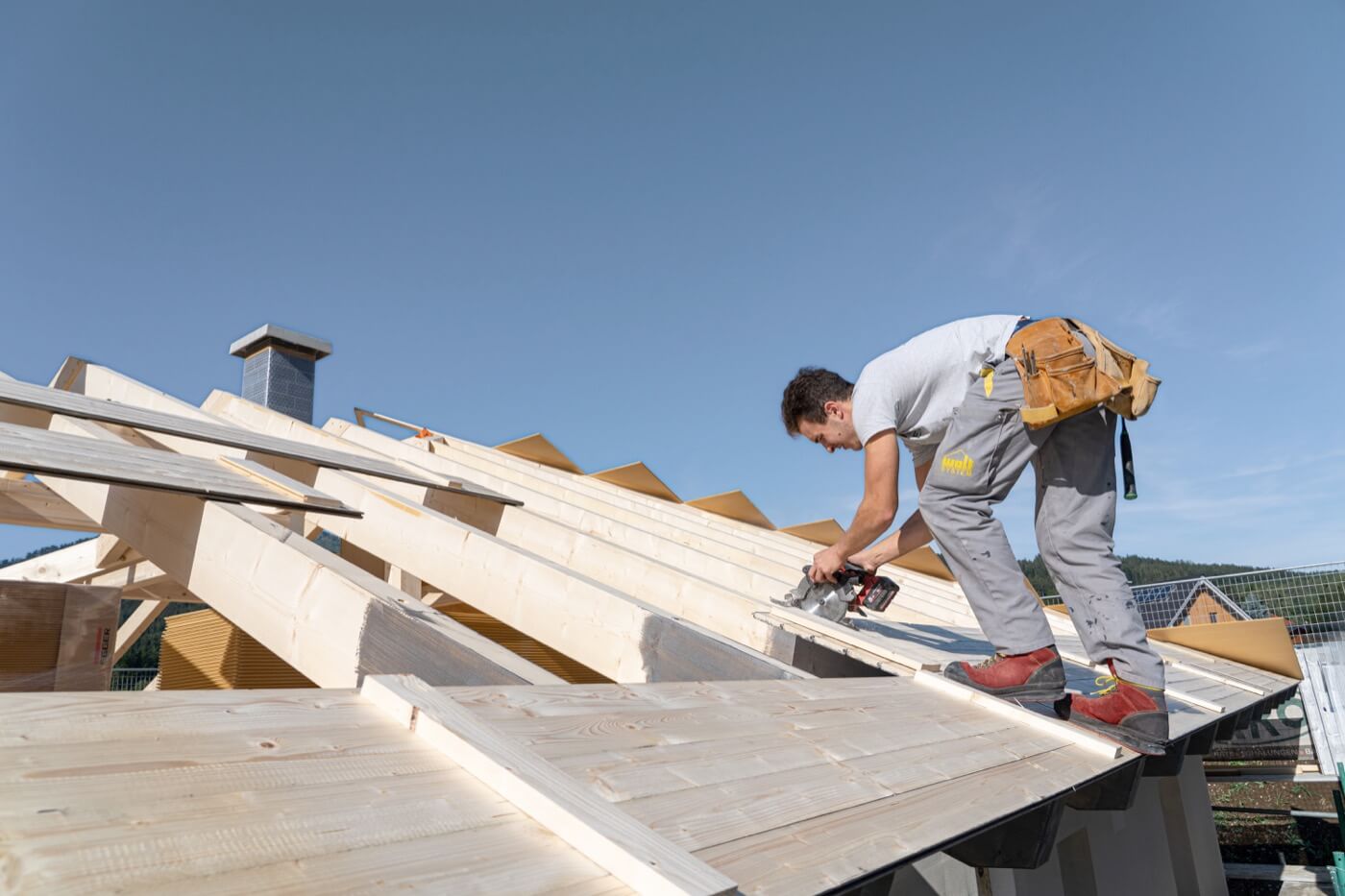 Bauarbeiter bei der Arbeit auf einem im Bau befindlichen Holzdachstuhl.
