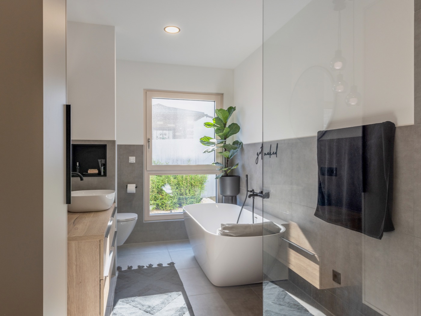 Badezimmer in einem Haus von HARTL HAUS, das durch eine offene Raumgestaltung besticht.