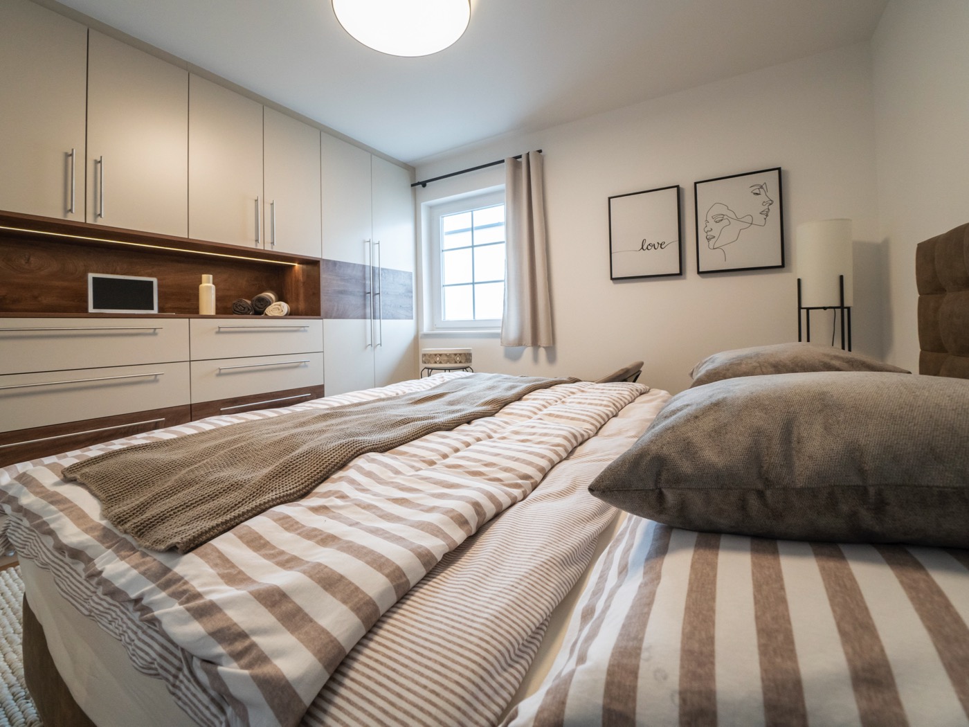 Schlafzimmer mit großem Bett und integrierten Kleiderschränken eines Fertigteilhauses vom Hersteller Wolf Haus.