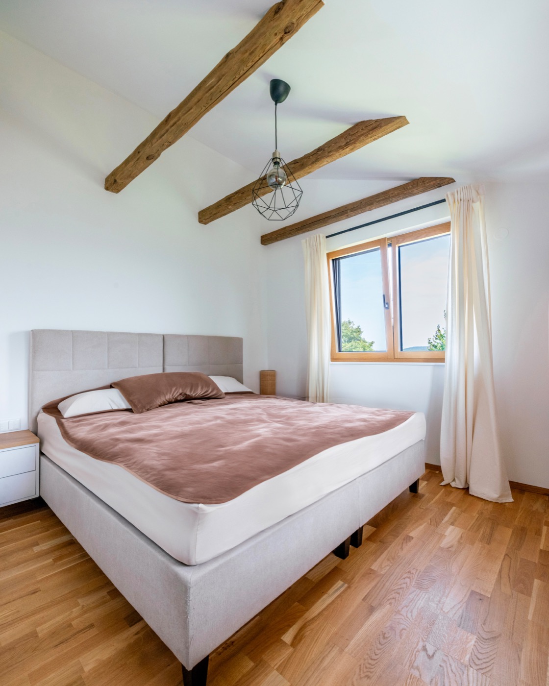 Schlafzimmer, das die gemütliche und natürliche Linie des restlichen Hauses konsequent in den privaten Ruhebereich fortführt.