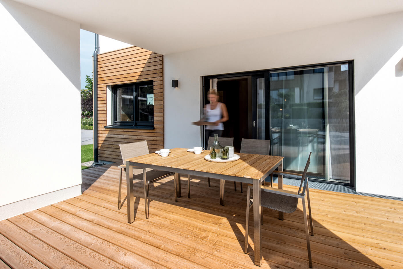 Moderne Terrassenszene, die den fließenden Übergang zwischen Innen- und Außenbereich eines Wohnhauses betont.