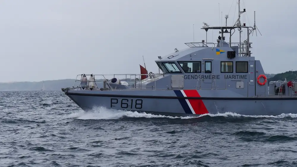 Un patrouilleur de la Gendarmerie maritime, le P618, navigue sur l'eau. Le navire est de couleur grise avec des bandes bleues, blanches et rouges sur la proue, et porte l'inscription 'Gendarmerie maritime'.