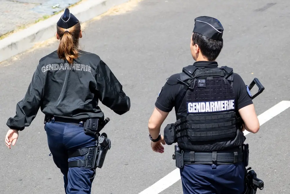 Deux gendarmes en uniforme, se déplaçant rapidement, illustrant l'action et la réactivité des forces de gendarmerie dans le cadre d'une mission d'enquête ou d'intervention.