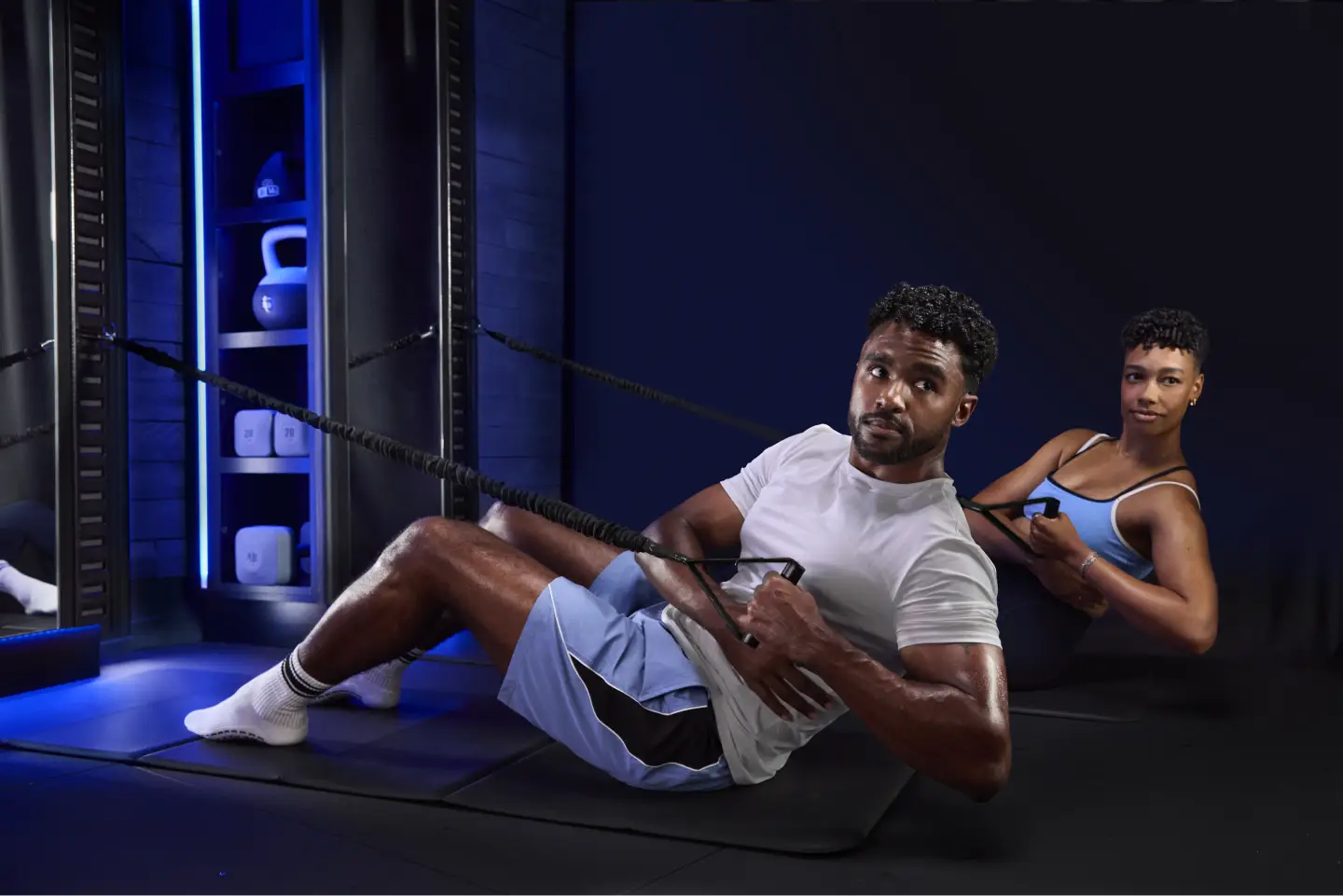 Two members training with resistance cables during a [solidcore] ascend Strong50 class