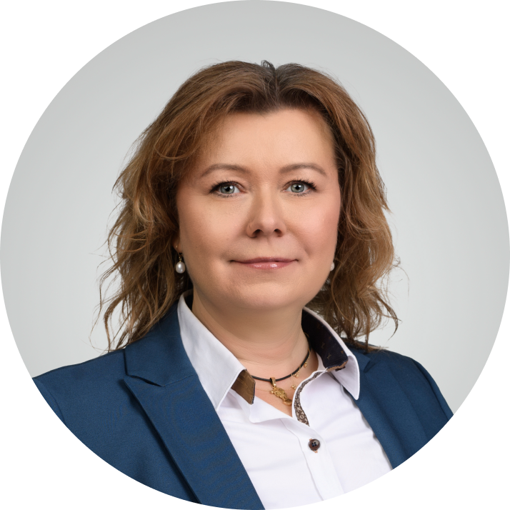 Professional headshot of a woman with light brown hair wearing a blue blazer and white shirt, smiling slightly against a white background.