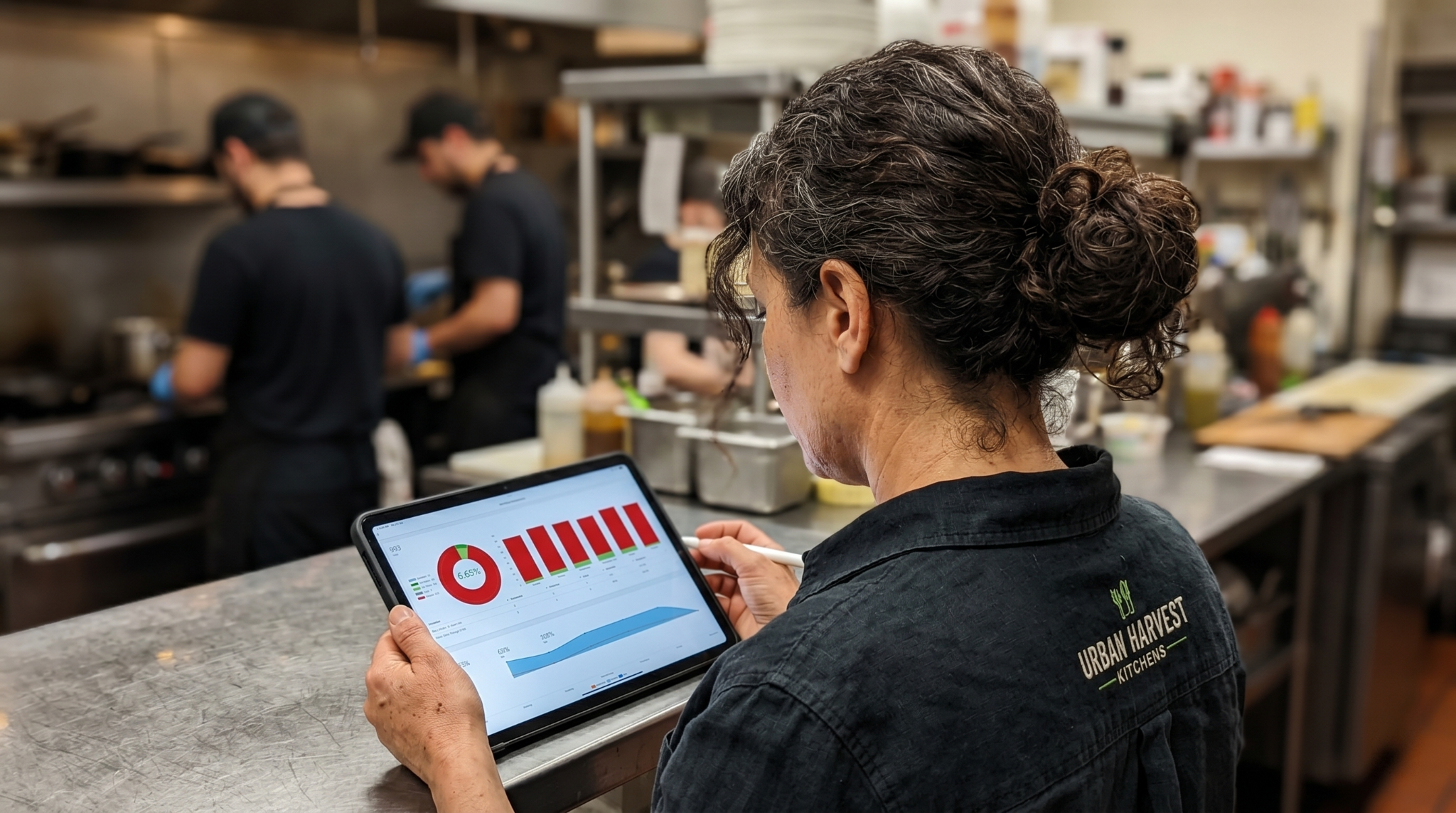 Multi-location restaurant manager reviewing digital operations dashboard on a tablet