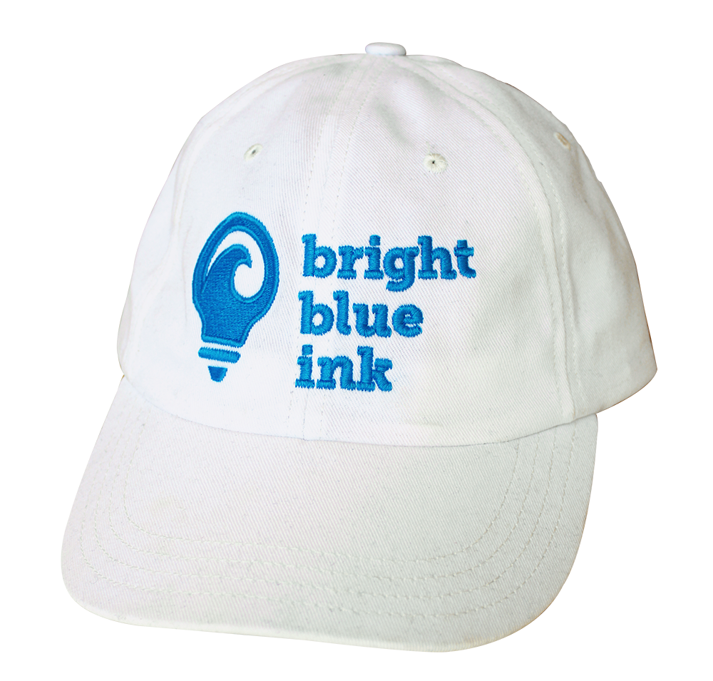 A woman smiling wearing a white t-shirt with the Bright Blue Ink logo printed on it.