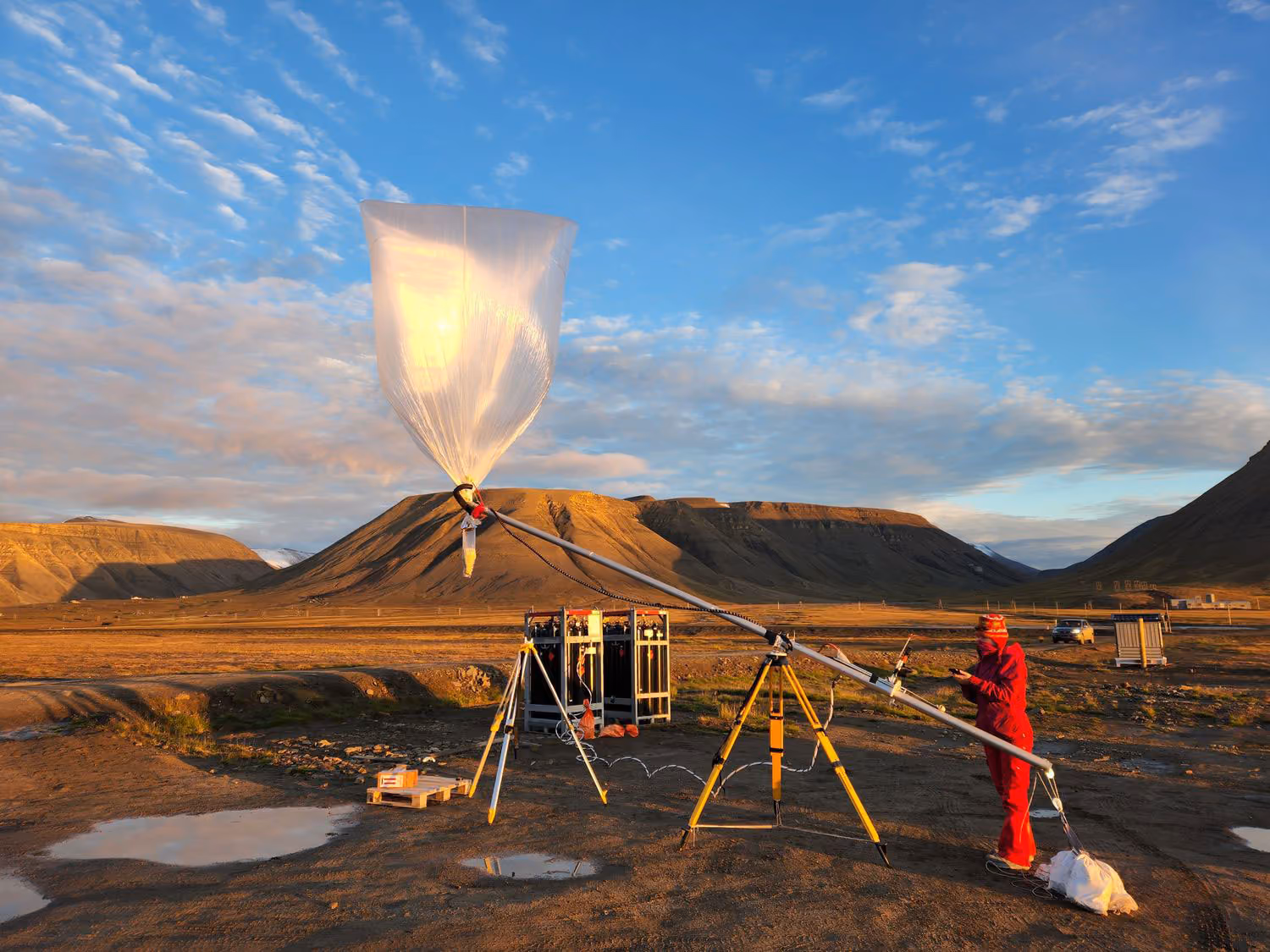 Female engineer operating balloon launch rig in a scenic mountainous background