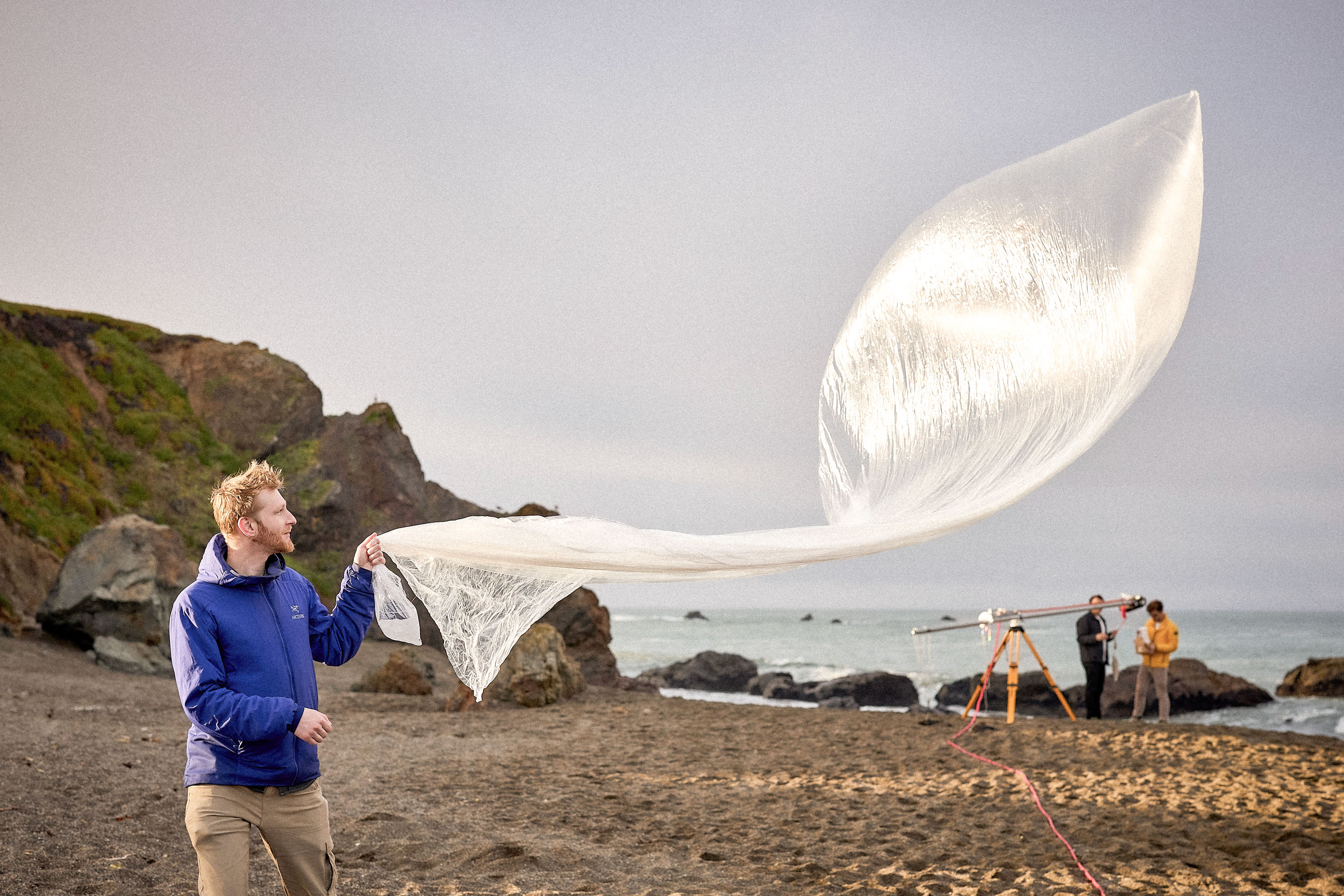 Man holding a balloon envelope as it flutter through the wind