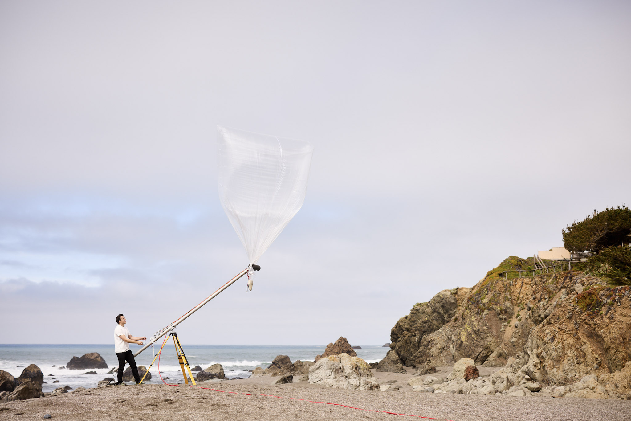 Man launching balloon on beach using launch rig