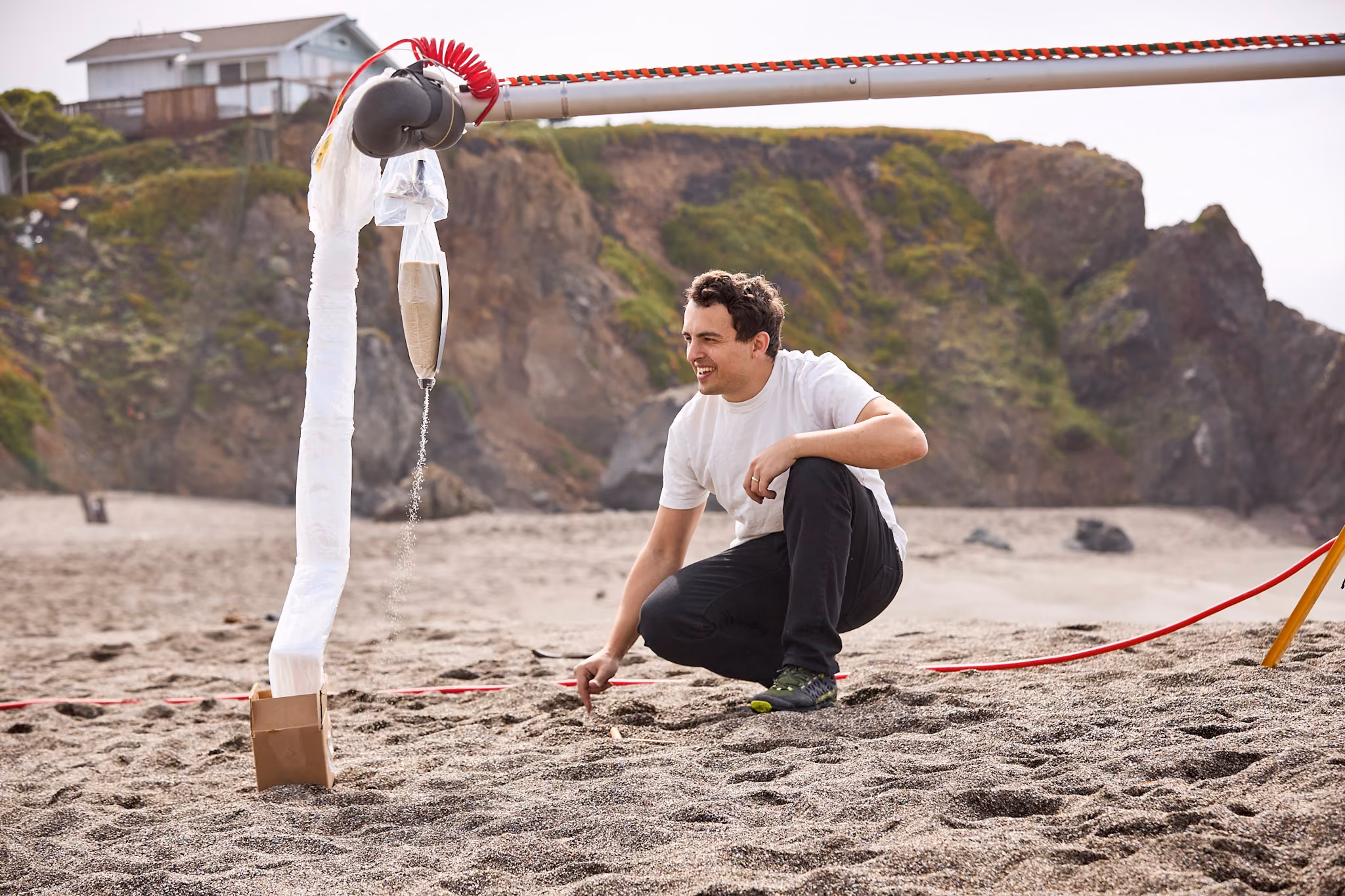 Engineer looking at WindBorne hardware on the beach