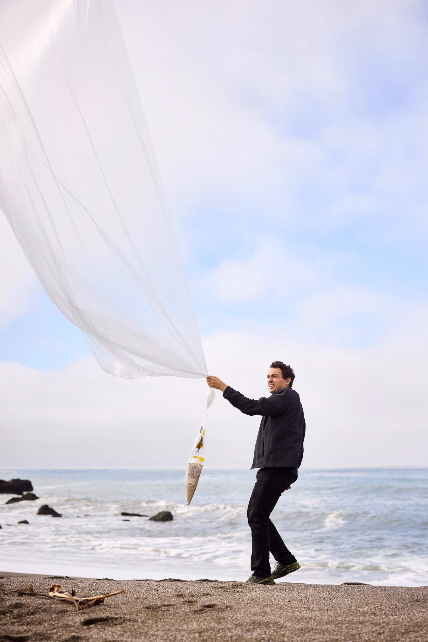 Man holding a weather balloon on the beach
