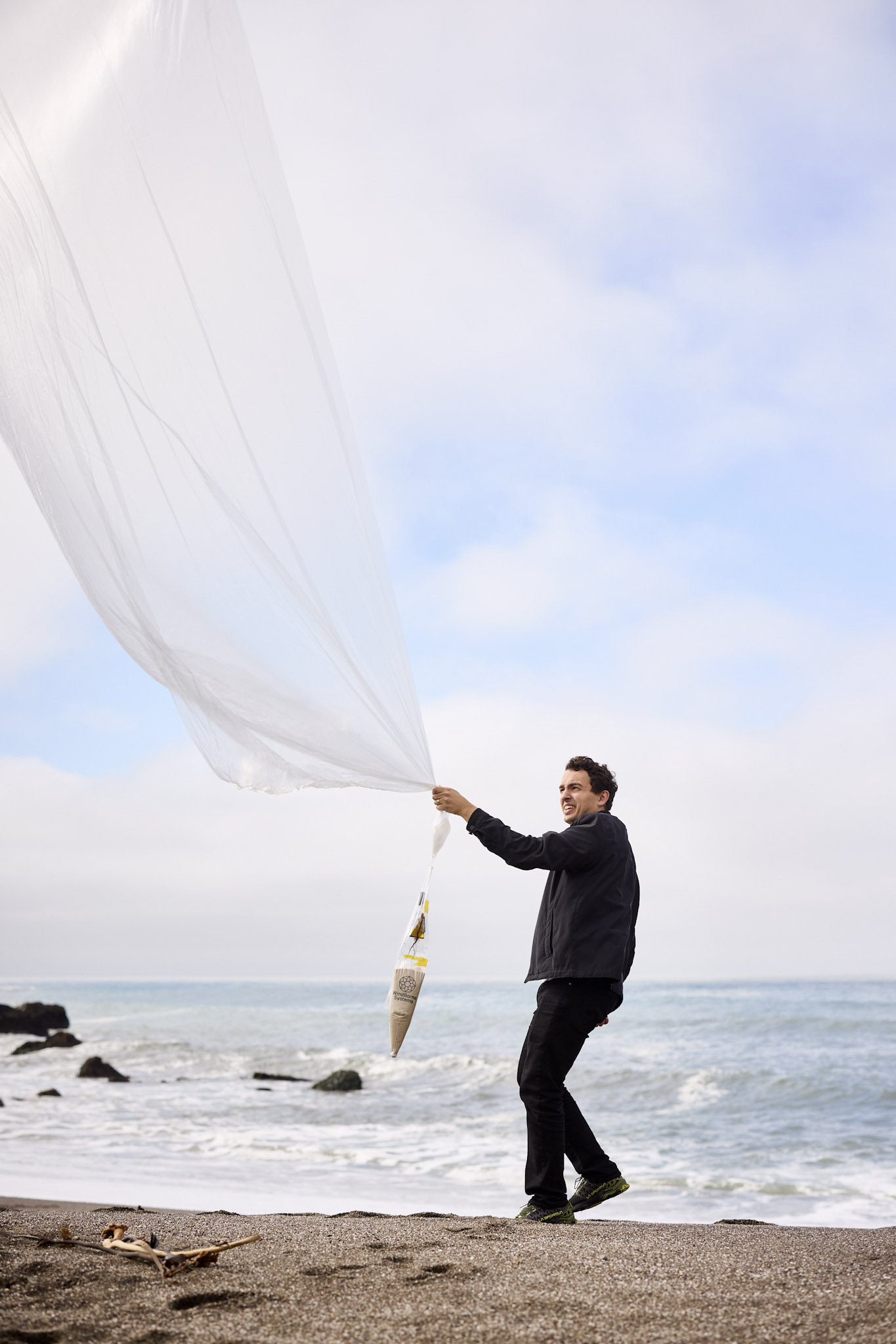 Man holding a weather balloon on the beach