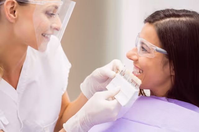 Odontólogo eligiendo carillas dentales para una mujer
