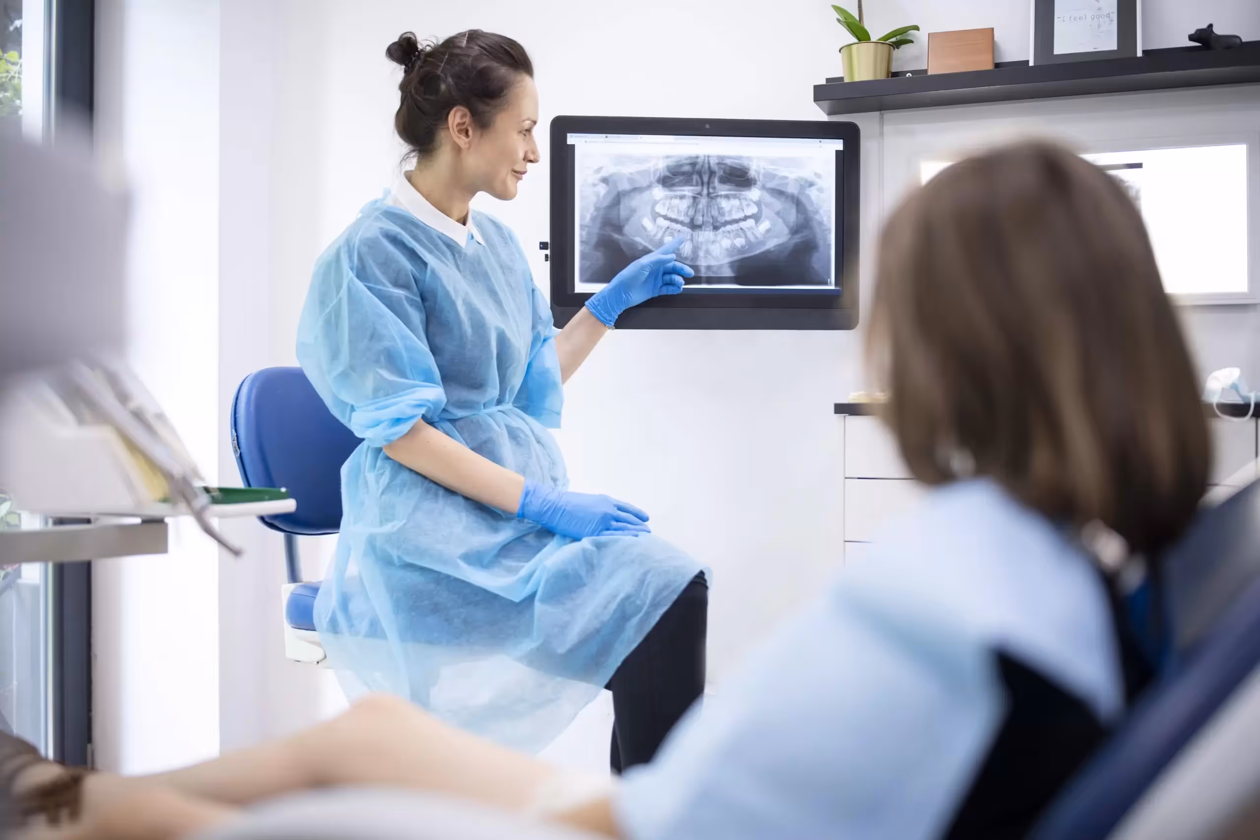Dentista mostrando a su paciente una radiografia panorámica