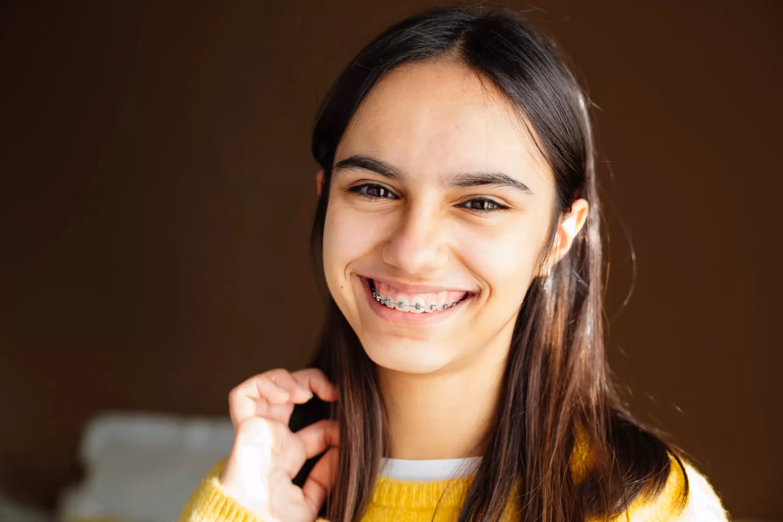 Joven sonriendo para mostrar sus brackets autoligables