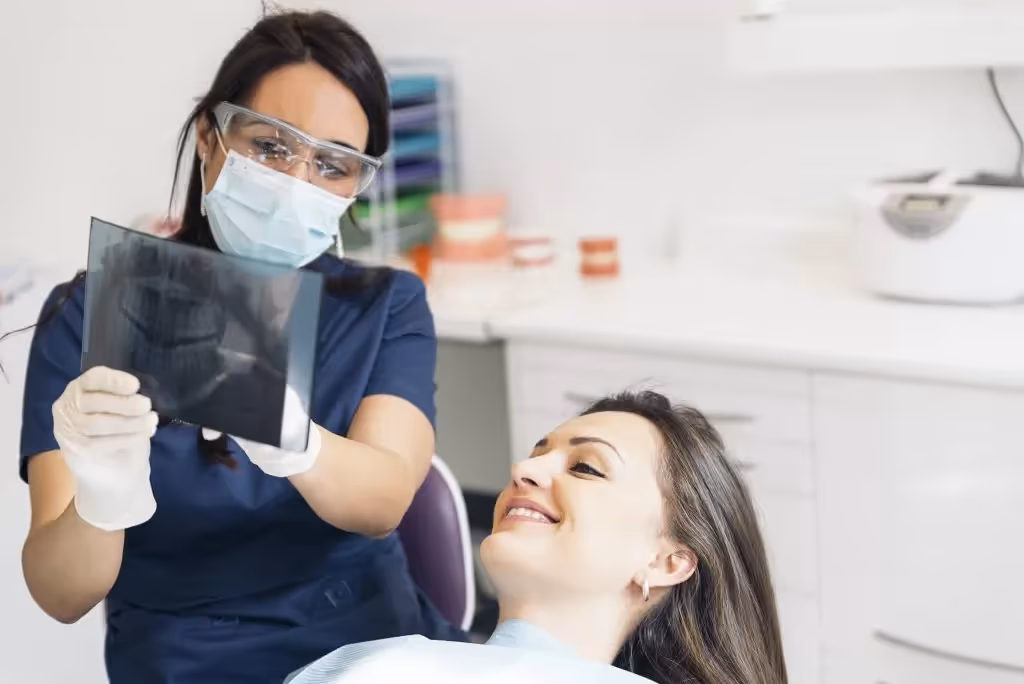 Dentista mostrando a un paciente sus imágenes dentales.