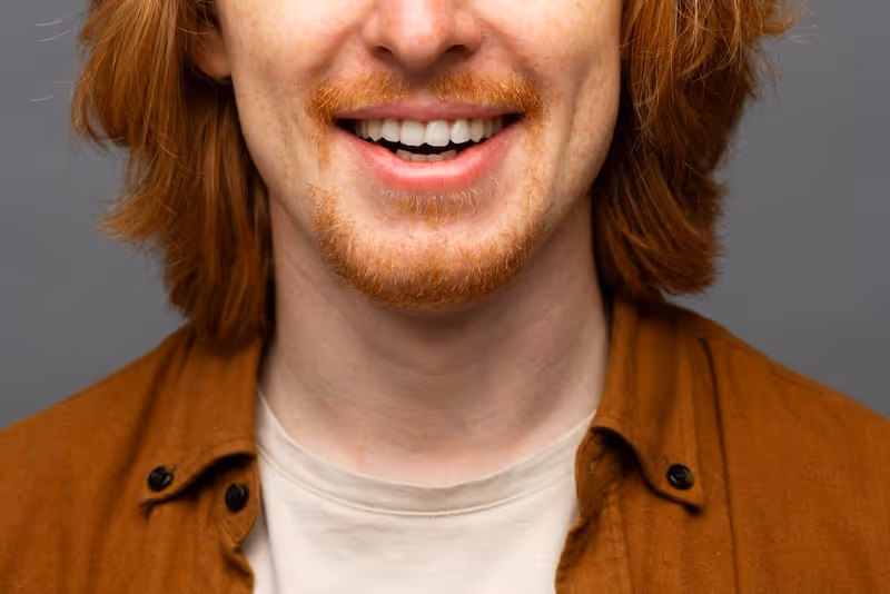 Hombre sonriendo a con sus dientes color blanco