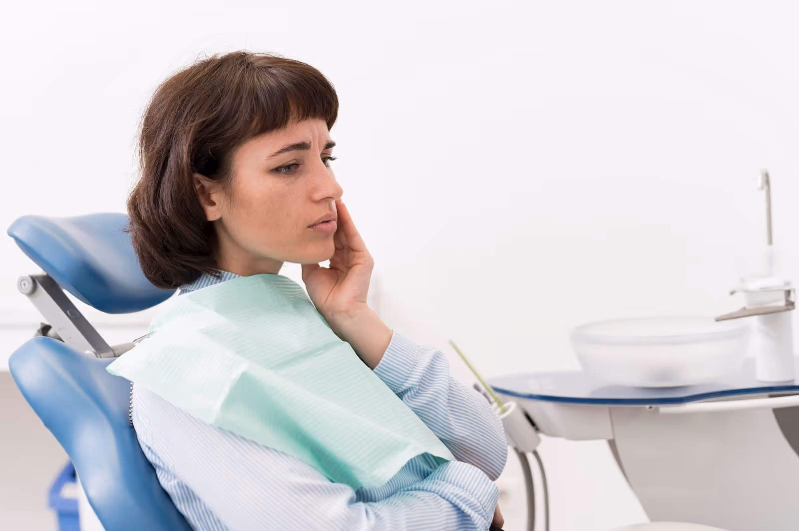 Mujer preocupada en el consultorio del odontólogo