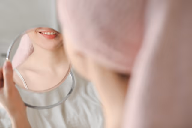 mujer mirandose los dientes blancos en el espejo 