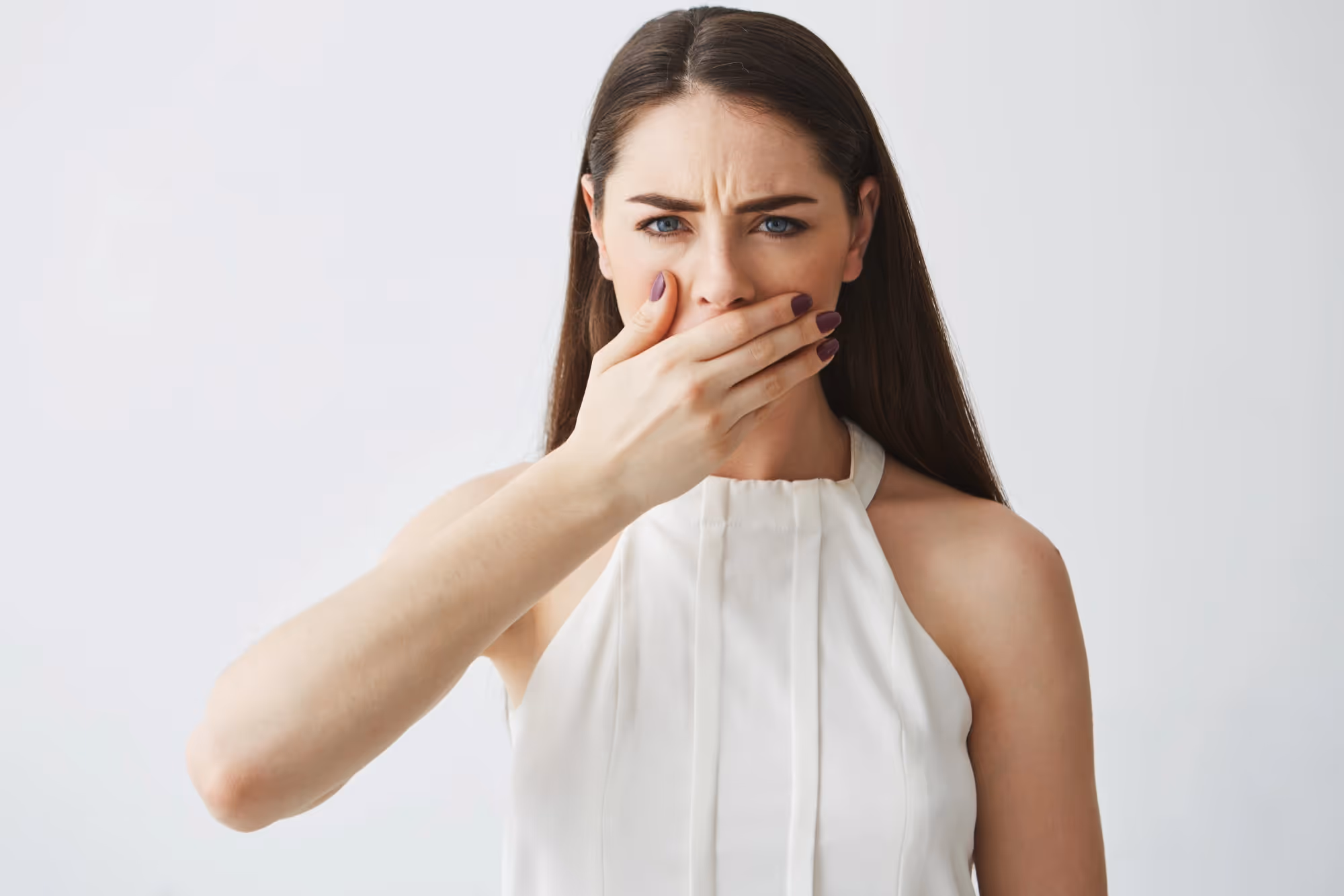 Chica cubriéndose la boca por mal aliento